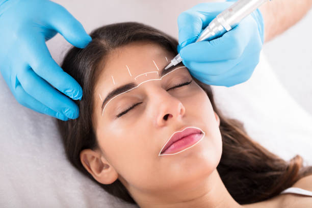 lhbeautylounge-Cosmetologist Applying Permanent Make Up On Woman's Eyebrows In Beauty Spa